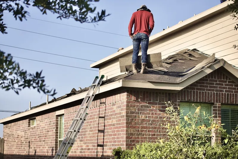 Professional roofer working on a residential roof in March Field